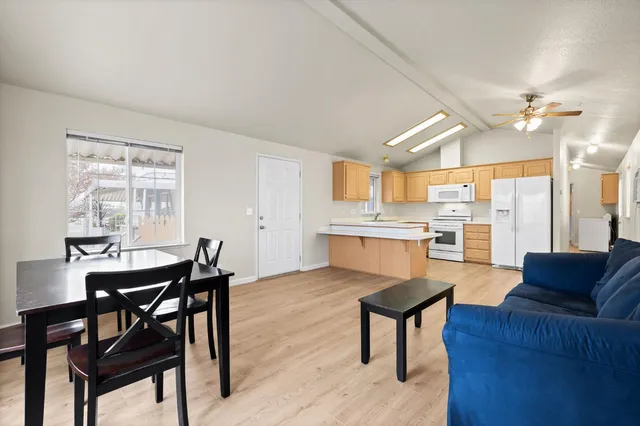 a living room with stainless steel appliances kitchen island granite countertop furniture and a large window