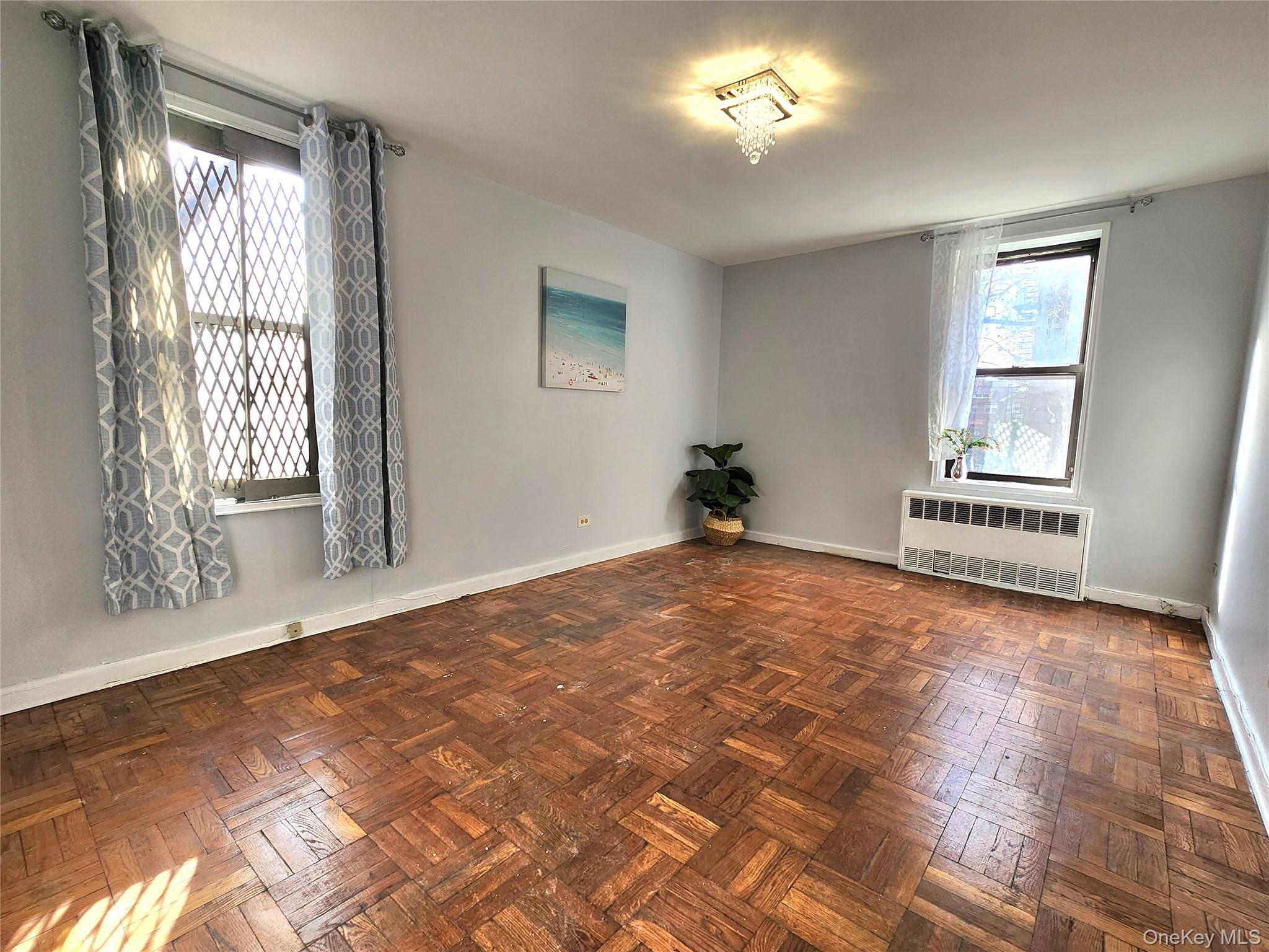 33-27 91st Street, Unit 1J Queens, NY 11372 - Photo 16 of 27 a view of empty room with wooden floor and fan