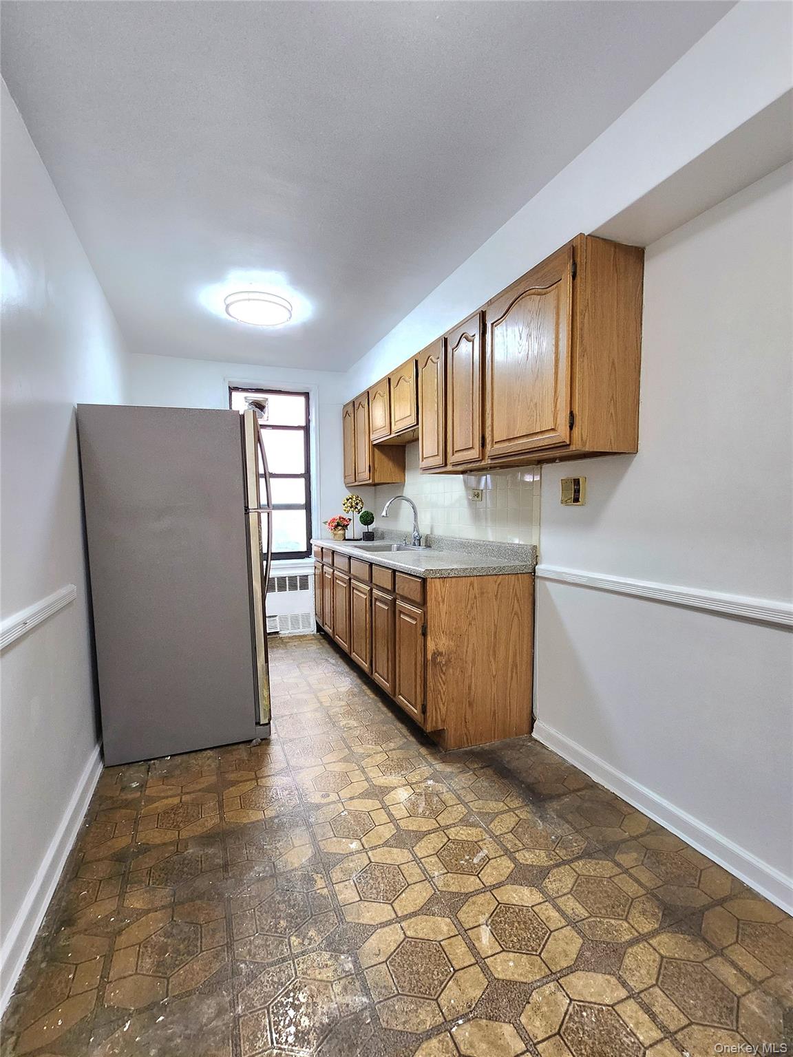 33-27 91st Street, Unit 1J Queens, NY 11372 - Photo 7 of 27 a kitchen with stainless steel appliances granite countertop a refrigerator and a stove top oven