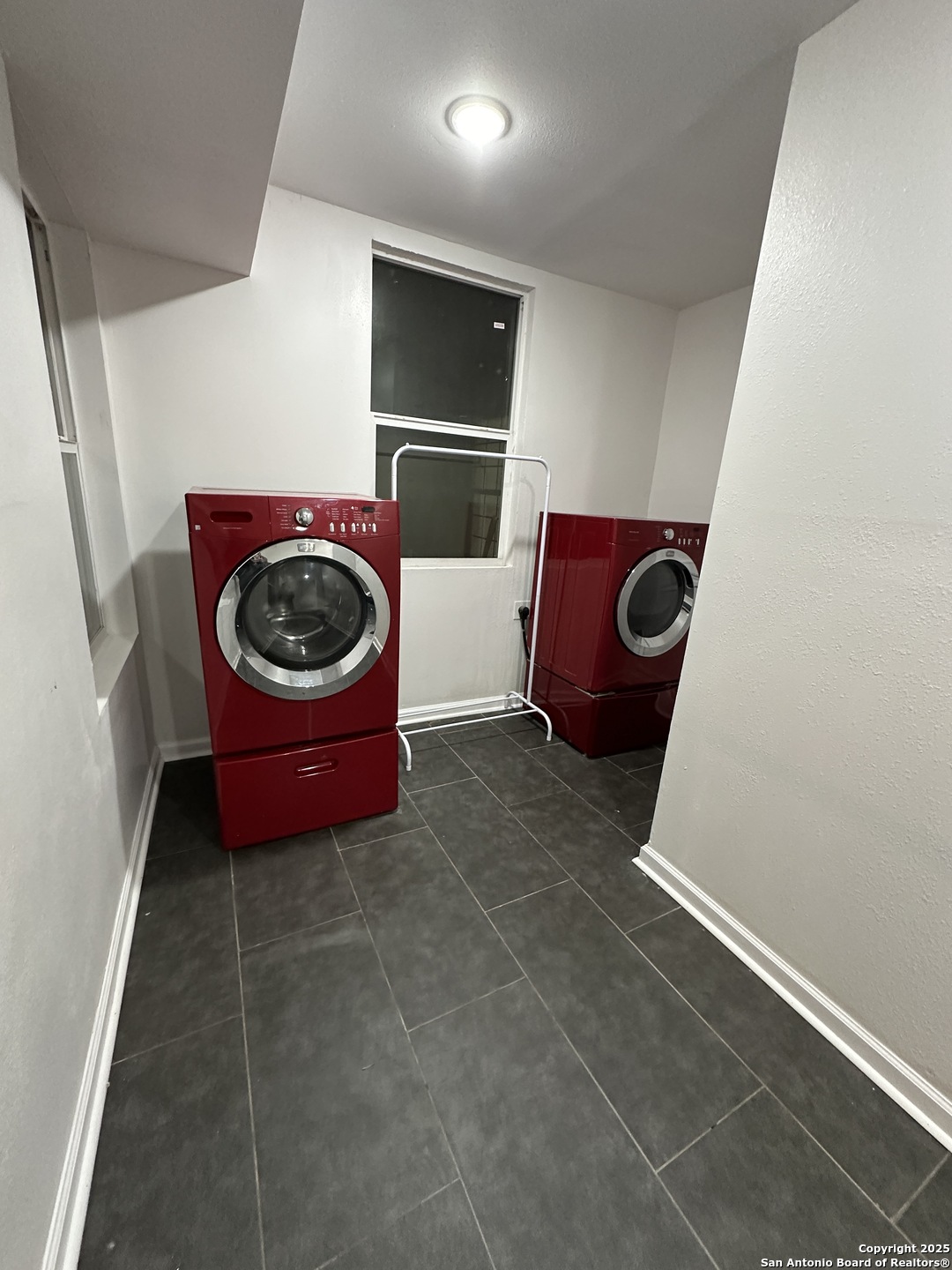 210 County Road 4643 Hondo, TX 78861 - Photo 7 of 13 a room with a chair and small washing machine