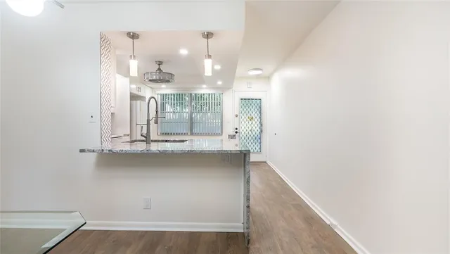 a view of kitchen and hall with wooden floor