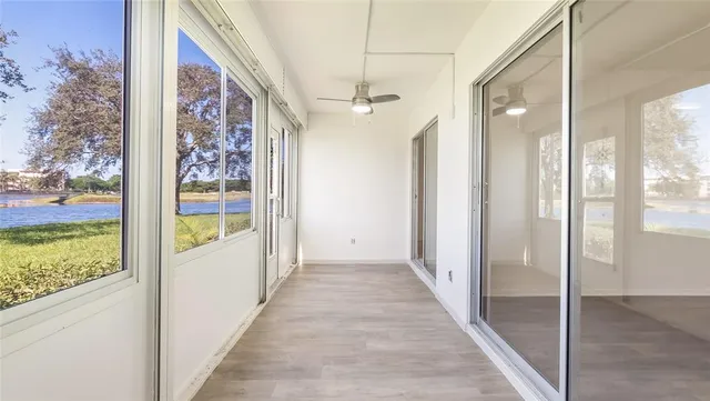 a view of a hallway with wooden floor and windows