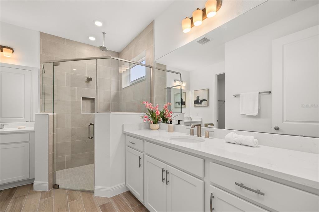 995 Fiesta Key Circle Lady Lake, FL 32159 - Photo 13 of 38 a bathroom with a shower sink and mirror