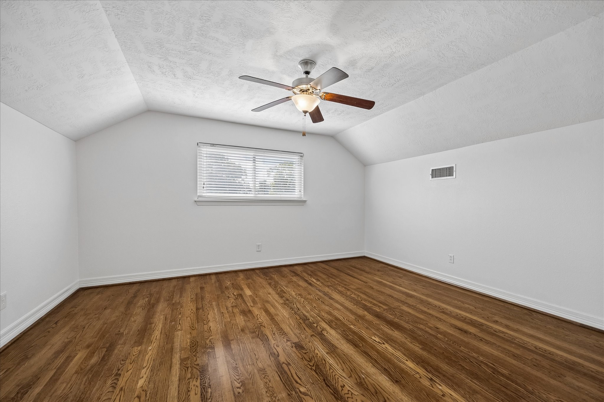 5019 Kinglet Street Houston, TX 77035 - Photo 14 of 24 Primary bedroom features gorgeous hardwood floors, vaulted ceilings, ceiling fan & upgraded windows with two inch slat blinds.