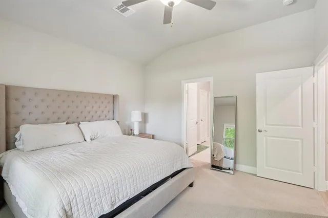a bedroom with a bed and a chandelier fan