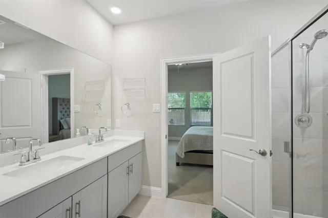 a en suite bathroom with a double vanity sink a mirror and a shower