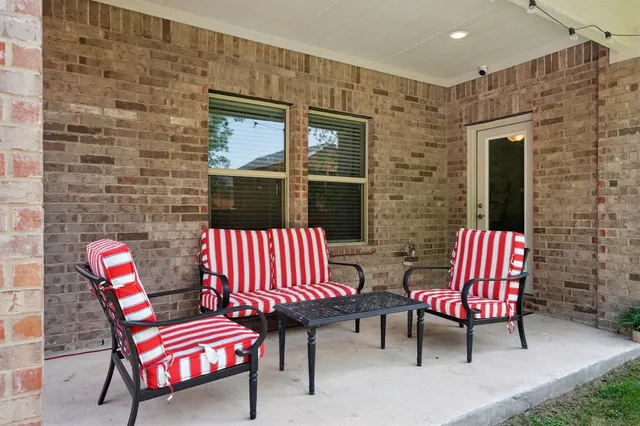a backyard with table and chairs and potted plants