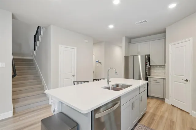 a kitchen with a sink a refrigerator and cabinets