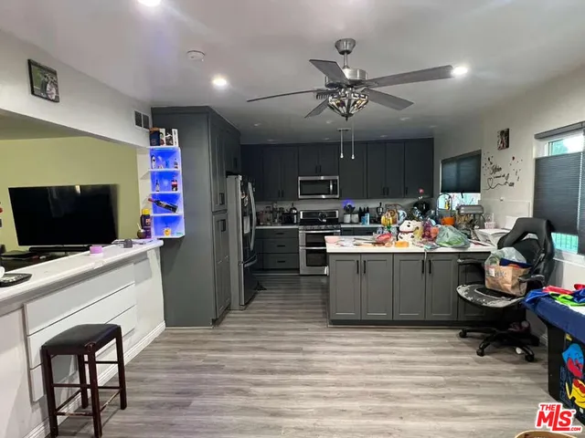 a kitchen with a refrigerator cabinets and wooden floor
