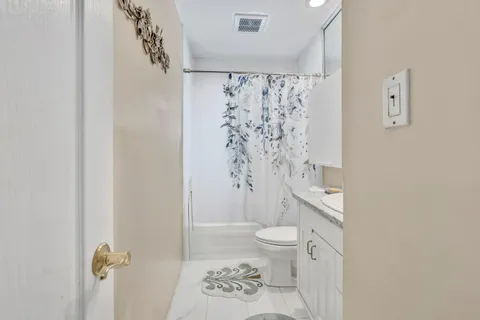 a bathroom with a granite countertop sink toilet and shower