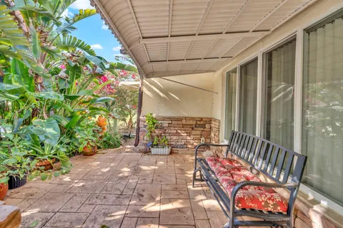 a balcony with chairs and with potted plants