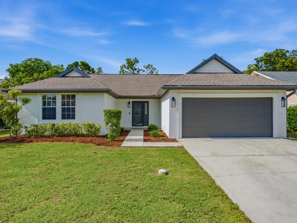3650 Kent Drive Naples, FL 34112 - Photo 3 of 17 a front view of a house with a yard and garage