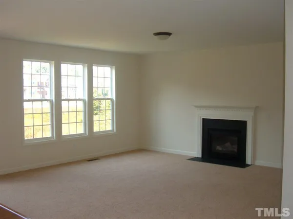 an empty room with a fireplace and window