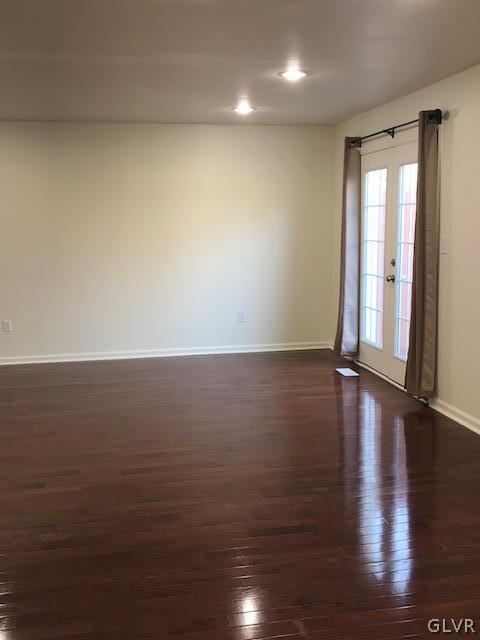3423 Limestone Drive Whitehall, PA 18052 - Photo 7 of 10 an empty room with wooden floor and windows with curtains