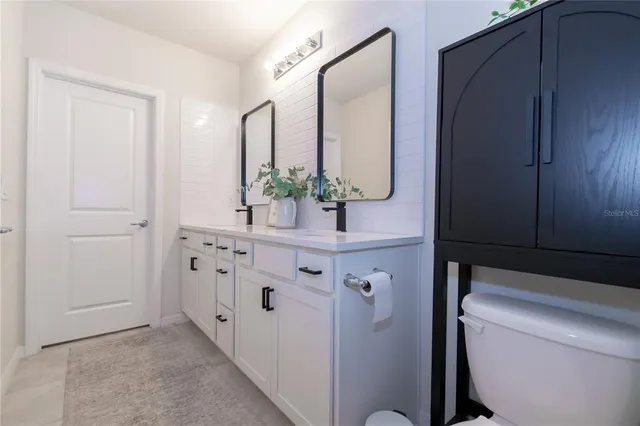 a bathroom with a double vanity sink and mirror