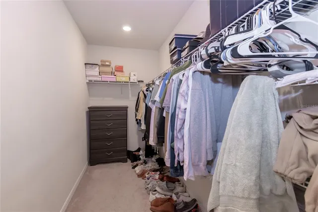 a view of walk in closet with clothes