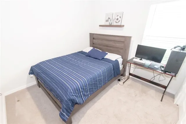 a bed sitting in a bedroom next to a chair