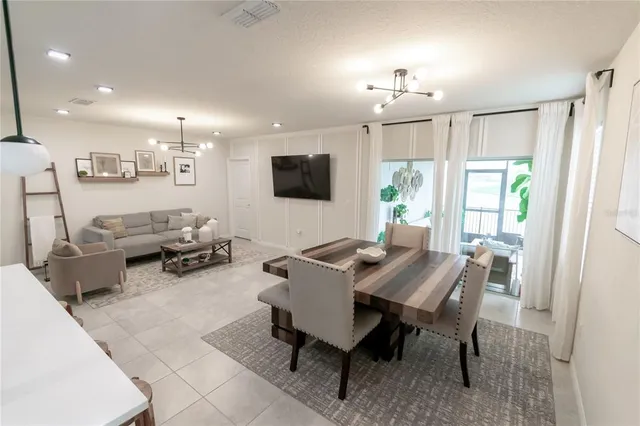 a living room with furniture a flat screen tv and a large window