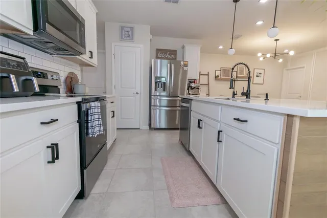 a kitchen with stainless steel appliances a sink stove and refrigerator