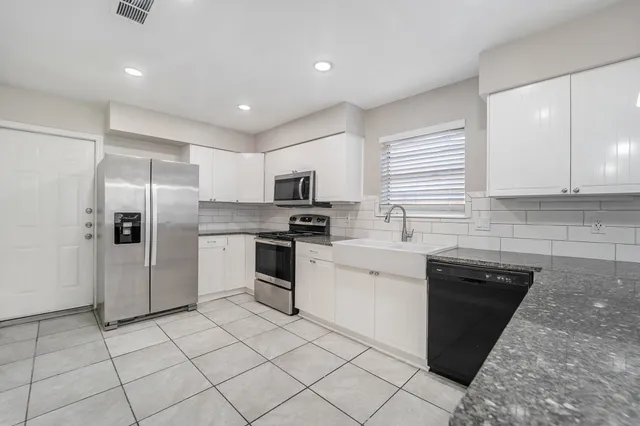 a kitchen with granite countertop cabinets and steel stainless steel appliances