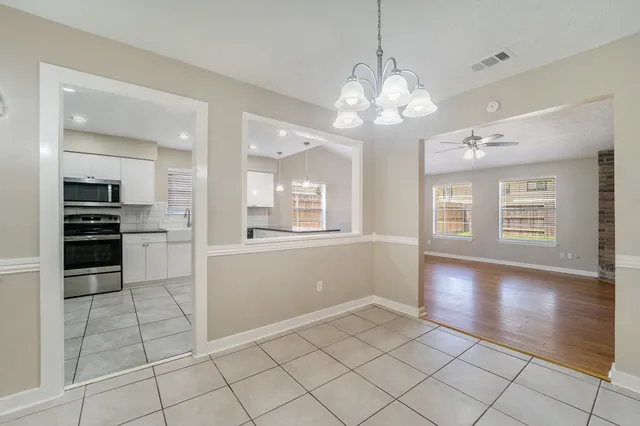a view of a kitchen with dishwasher and white cabinets with wooden floor