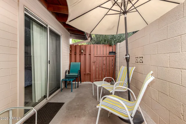 a view of a patio with table and chairs under an umbrella