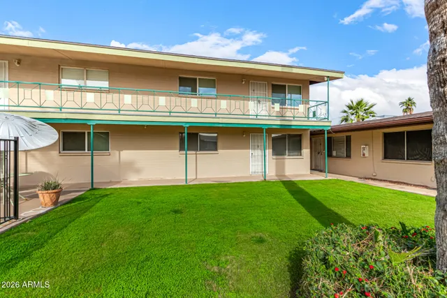 a view of an house with backyard space and balcony