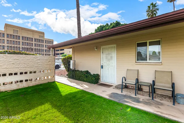 a view of a chair and table in backyard of the house