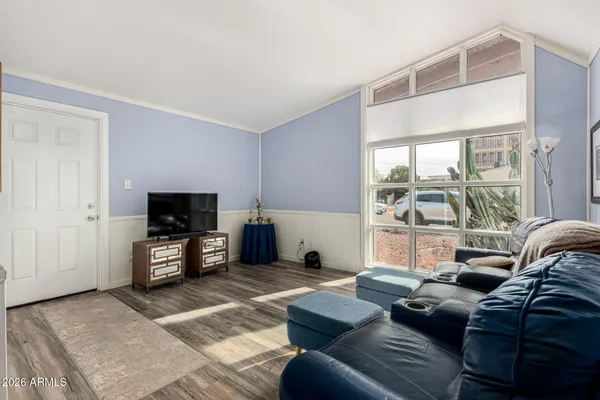 a living room with furniture a flat screen tv and a large window