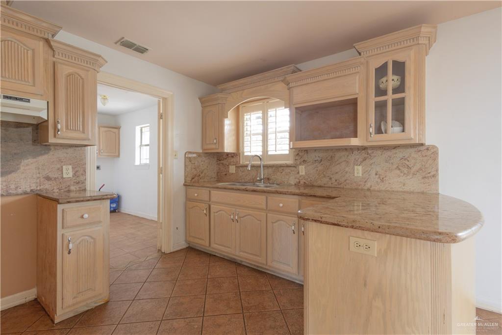 3909 Tulipan Street Mission, TX 78573 - Photo 16 of 18 a bathroom with a granite countertop sink a mirror and a bathtub