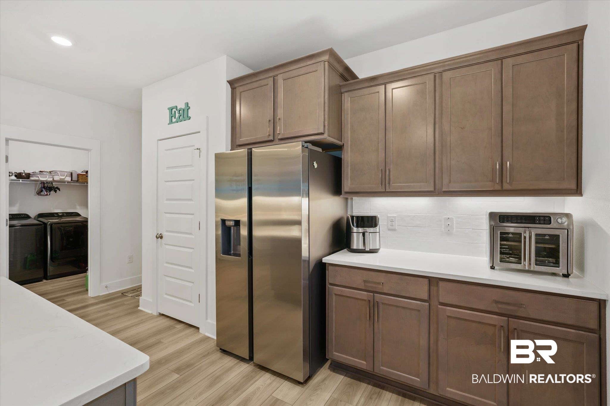 263 Bronze Street Fairhope, AL 36532 - Photo 9 of 47 Kitchen with washer and clothes dryer, stainless steel fridge, and light hardwood / wood-style floors