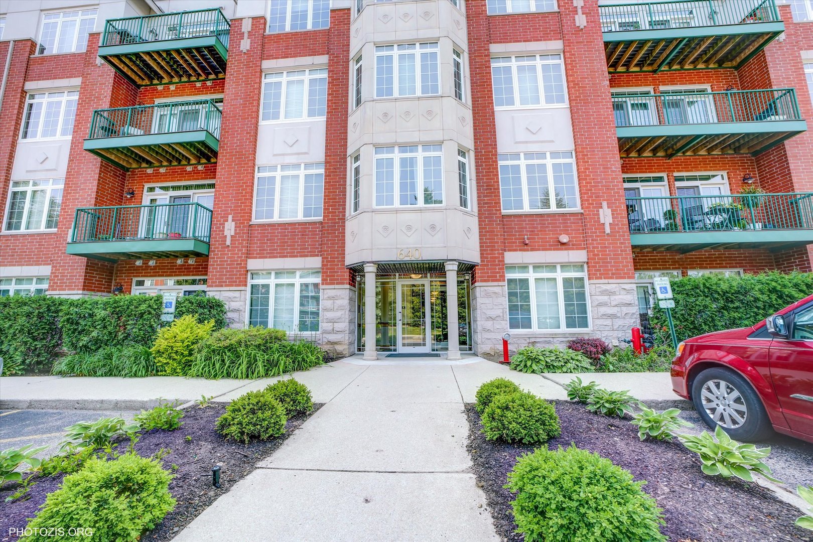 640 McHenry Road, Unit 106 Wheeling, IL 60090 - Photo 2 of 4 a front view of a multi story building with yard
