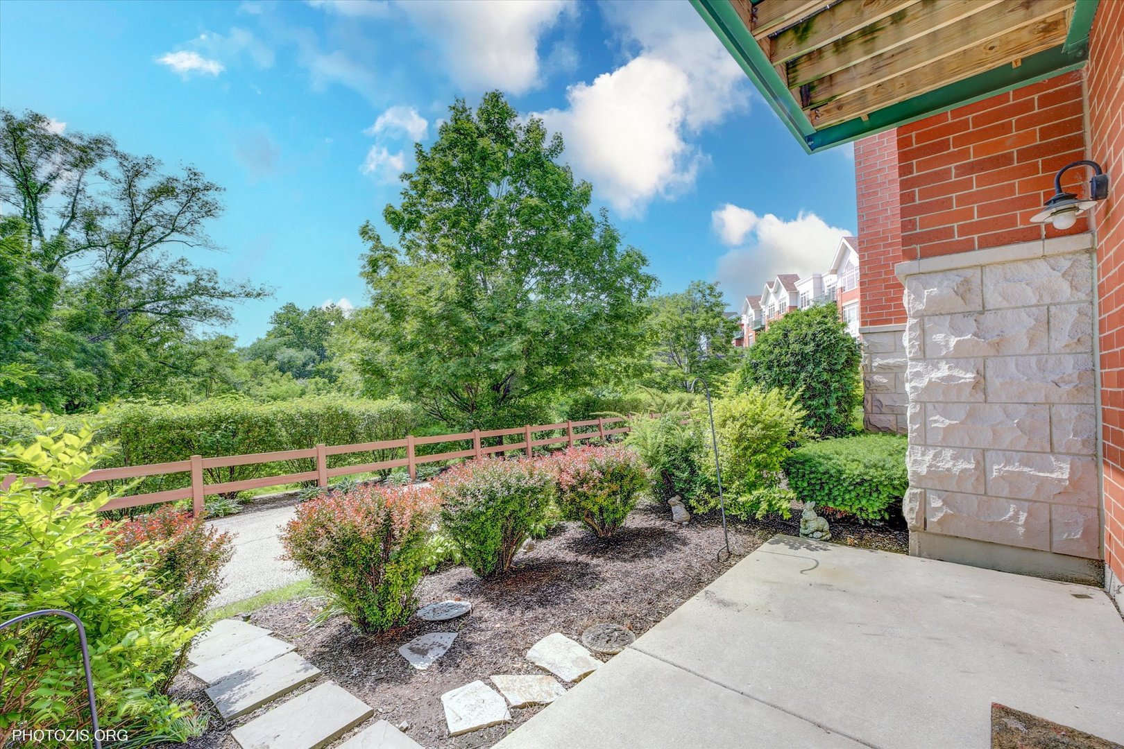 640 McHenry Road, Unit 106 Wheeling, IL 60090 - Photo 3 of 4 a view of a yard with plants and a bench