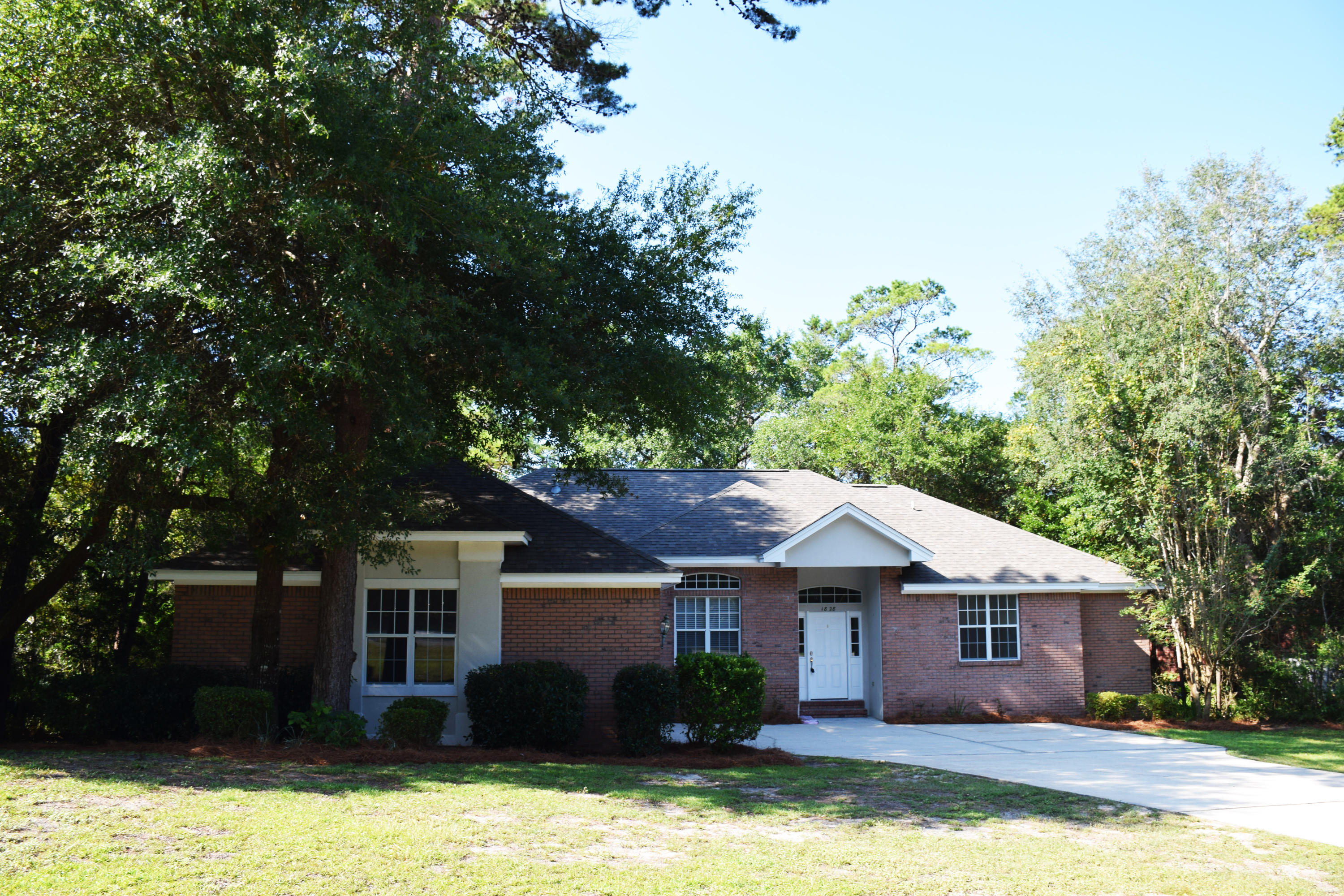 1828 Huntington Road Niceville, FL 32578 - Photo 1 of 27 a front view of a house with a yard garage and outdoor seating