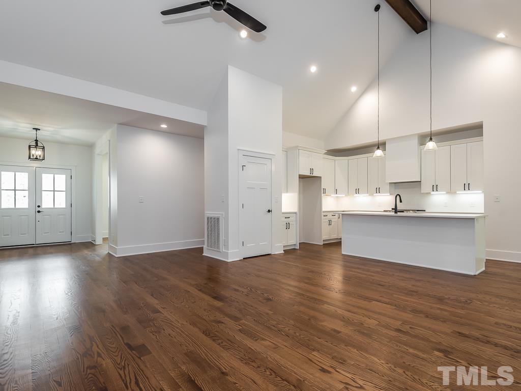 1703 Milton Road Durham, NC 27712 - Photo 7 of 39 a view of an empty room and kitchen with wooden floor