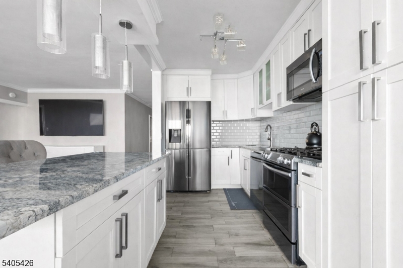 6 Horizon Road, Unit 2809 Fort Lee, NJ 07024 - Photo 9 of 19 a large kitchen with stainless steel appliances granite countertop a stove top oven a refrigerator and a sink