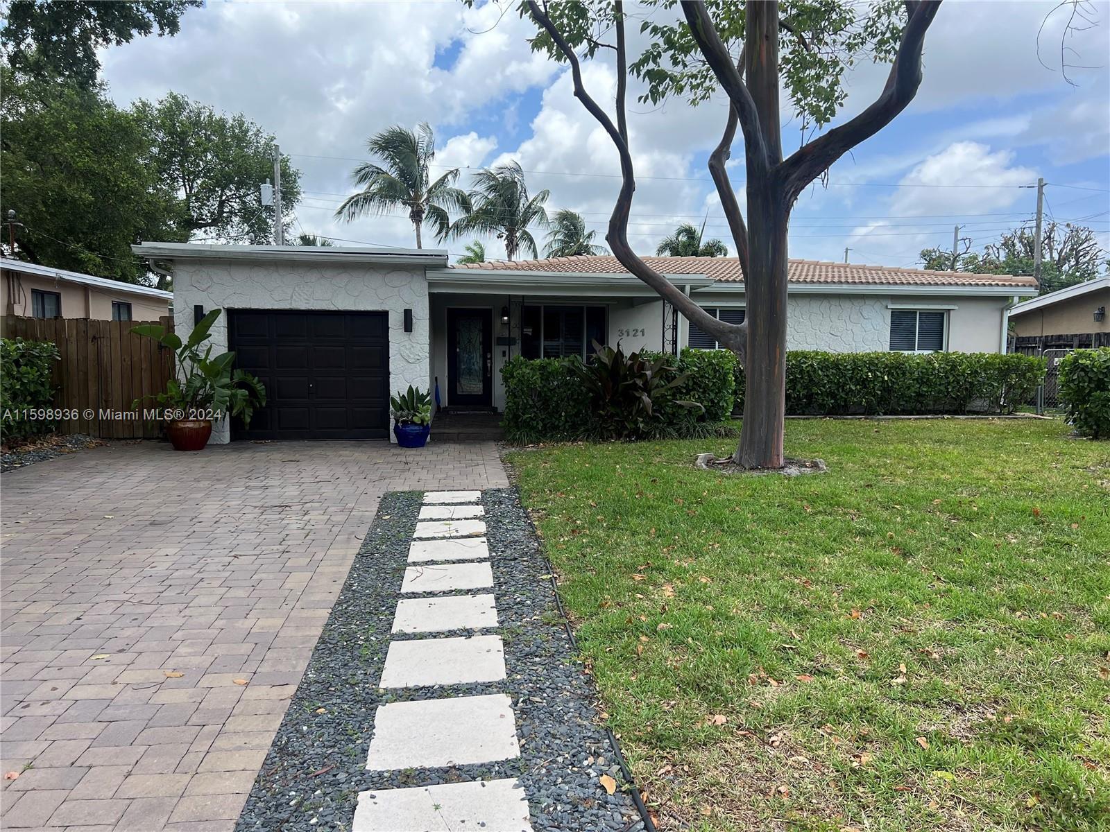 3121 Riverland Road Fort Lauderdale, FL 33312 - Photo 1 of 7 a front view of a house with a garden and trees