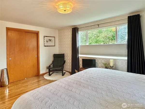 a bedroom with a bed and painting on the wall