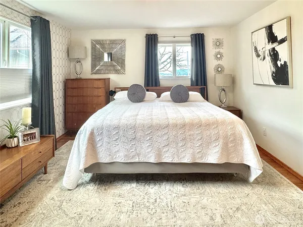 a bedroom with a bed and painting on the wall
