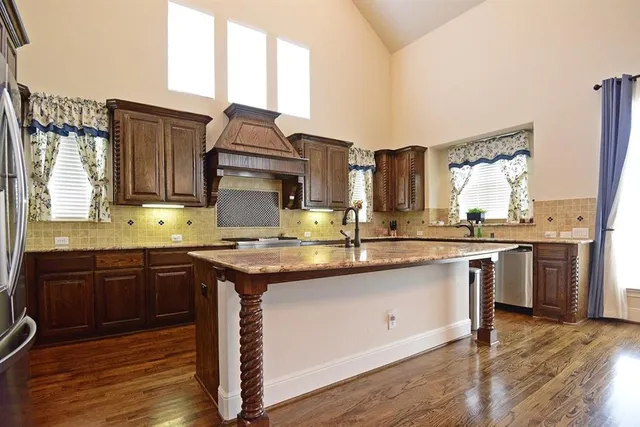 a kitchen with granite countertop a sink cabinets and wooden floor