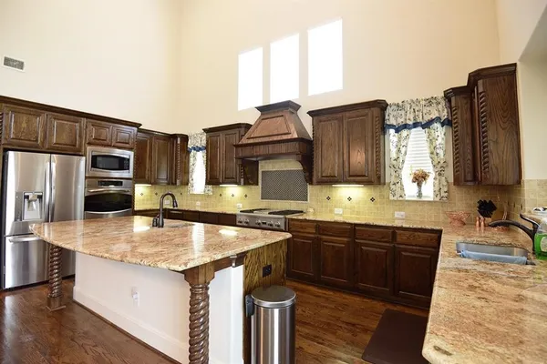 a kitchen with stainless steel appliances granite countertop a sink stove and refrigerator