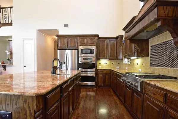 a kitchen with granite countertop stainless steel appliances and wooden cabinets