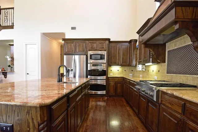 a kitchen with granite countertop stainless steel appliances and wooden cabinets