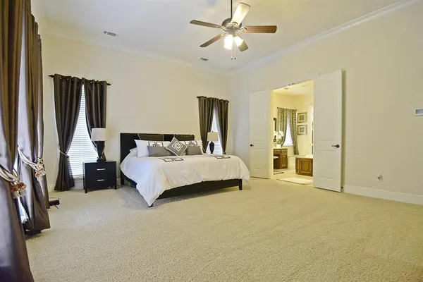 a spacious bedroom with a bed and a chandelier