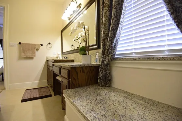 a bathroom with a granite countertop sink and a mirror