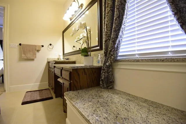a bathroom with a granite countertop sink and a mirror