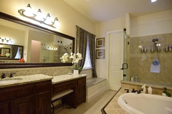 a bathroom with a bathtub shower sink double and mirror