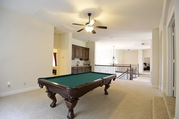 a living room with pool table and a ceiling fan
