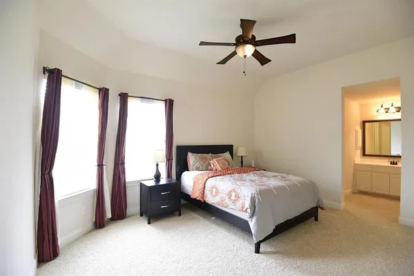 a bed sitting in a bedroom next to a window