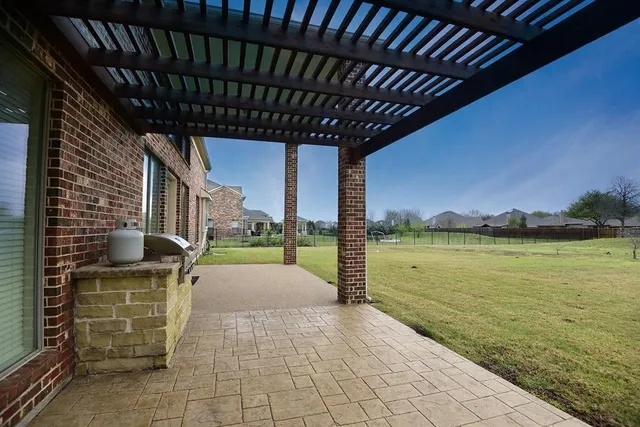 a view of a patio with a table chairs under an umbrella